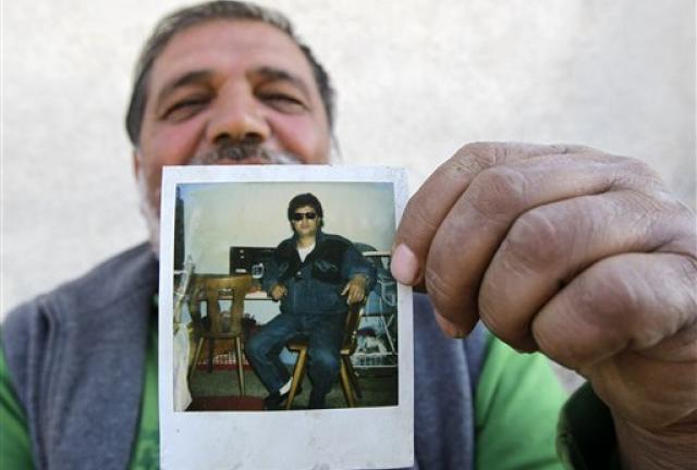 In this Oct. 22, 2012 photo Senad Ajeti, Azra Ajeti's husband, shows a Polaroid photo of himself taken during his asylum in Germany, in the town of Bujanovac, 340 kms south of Belgrade, Serbia.