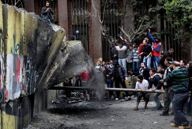 Egyptian protesters try to tear down a cement wall built to prevent them from reaching parliament and the Cabinet building in Cairo, Egypt, on Jan. 24, 2012. Egyptian protesters try to tear down a cement wall built to prevent them from reaching parliament and the Cabinet building in Ca