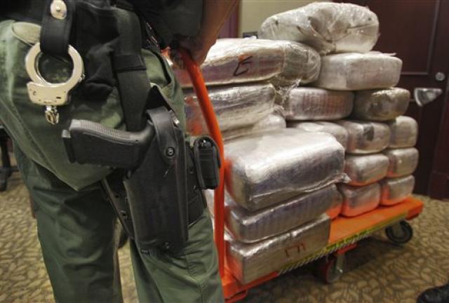 FILE - In this Nov. 4, 2010 file photo, bales of marijuana are wheeled out at a news conference in Jonesboro, Ga. Forty-five people were arrested 45 people along with cash, guns and more than two tons of drugs as part of an investigation by federal and local law enforcement into the Atlanta-area U.S. distribution hub of Mexico's La Familia drug cartel. Drug cartels have long been the nation’s No. 1 supplier of illegal drugs, but in the past, their operatives rarely ventured beyond the border. 