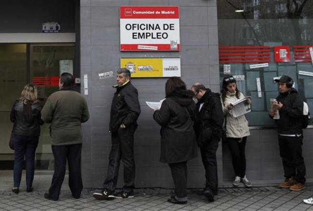 People wait outside an unemployment office in Madrid, Spain, Tuesday, April 2, 2013. 