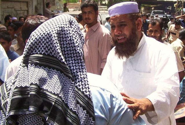 Pakistani relatives and residents gather outside the residence of slain candidate, Fakhrul Islam, 46, who was a candidate for the secular Muttahida Qaumi Movement (MQM), following an attack by gunmen in the southern city of Hyderabad on April 11, 2013. 