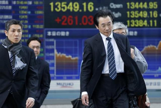 People walk in front of an electronic stock indicator in Tokyo, Thursday, April 11, 2013. People walk in front of an electronic stock indicator in Tokyo, Thursday, April 11, 2013.