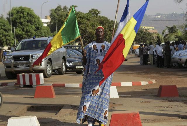 A man carries the national flags of Mali (L), France (C) and Republic of Chad on Martyrs' Day, celebrated as a commemoration of the day when General Moussa Traore's rule was overthrown on March 26, 1991, in Bamako March 26, 2013. A man carries the national flags of Mali (L), France (C) and Republic of Chad on Martyrs' Day, celebrated as a commemoration of the day when General Moussa Traore's rule was overthrown on March 26, 1991, in Bamako March 26, 2013.