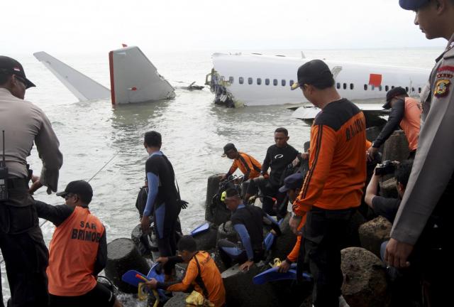 Indonesian divers get ready to retrieve a Lion Air jet plane’s cockpit voice recorder out of the wreckage of the plane near the Ngurah Rai International airport in Kuta, Bali, Indonesia on Monday, April 15, 2013. The Indonesian passenger jet carrying 108 people missed the runway as it came into land on the resort island on Saturday, slamming into the water at high speed and splitting in two. (AP Photo/Firdia Lisnawati)