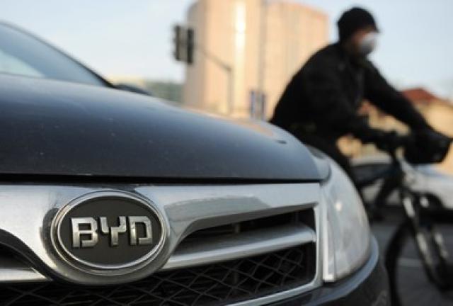A cyclist passes a BYD car on a street in Shanghai on March 25, 2013. A cyclist passes a BYD car on a street in Shanghai on March 25, 2013.