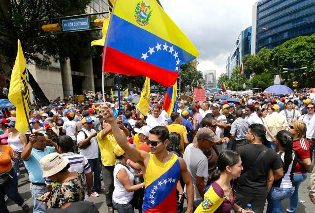 In this May 1, 2024 photo, members of the opposition hold Venezuelan flags during a May Day march in Caracas, Venezuela. 
