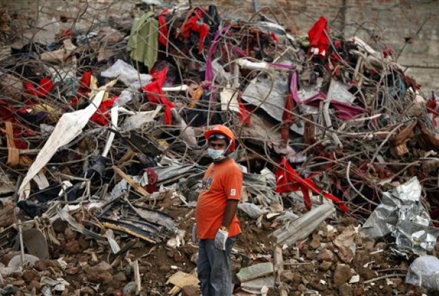 A Bangladeshi rescuer stands amid the rubble of a garment factory building that collapsed on April 24 as they continue searching for bodies in Savar, near Dhaka, Bangladesh, Sunday, May 12, 2013.