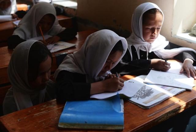 Afghan schoolgirls study during a lesson in Qara Zaghan village in Baghlan province on May 7, 2013. Afghanistan's education minister has threatened to punish students over cases when schools are hit by alleged 'poisonings' that many officials believe are actually temporary psychological illnesses. 