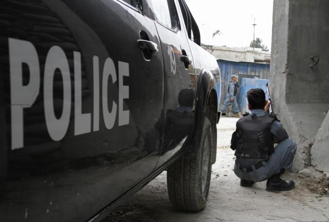 An Afghan policeman takes cover following a suicide attack in Kabul, Afghanistan, Friday, May 24, 2013. An Afghan policeman takes cover following a suicide attack in Kabul, Afghanistan, Friday, May 24, 2013.