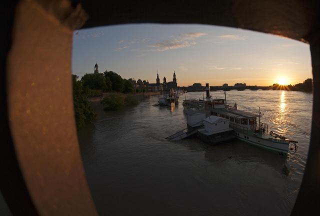 The sun goes down behind the flooded landing stages of the steamers by river Elbe in the old town of Dresden, eastern Germany, Wednesday, June 5, 2013.