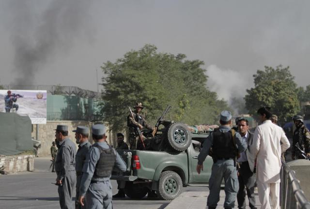 Afghan soldiers stand guard as smoke rises from the gate of the presidential palace in Kabul, Afghanistan, Tuesday June 25, 2013. 