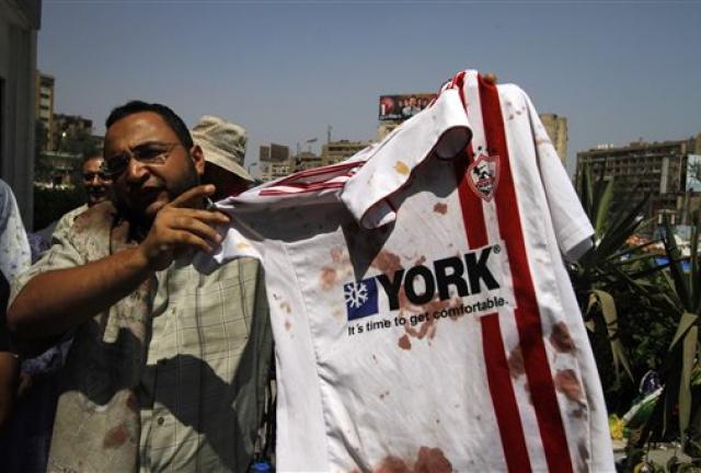 A supporter of ousted Egyptian President Mohammed Morsi stands outside a local hospital in Cairo holding a bloodied shirt he says belongs to a protester shot by soldiers during a demonstration, Monday, July 8, 2013. A supporter of ousted Egyptian President Mohammed Morsi stands outside a local hospital in Cairo holding a bloodied shirt he says belongs to a protester shot by soldiers during a demonstration, Monday, July 8, 2013.