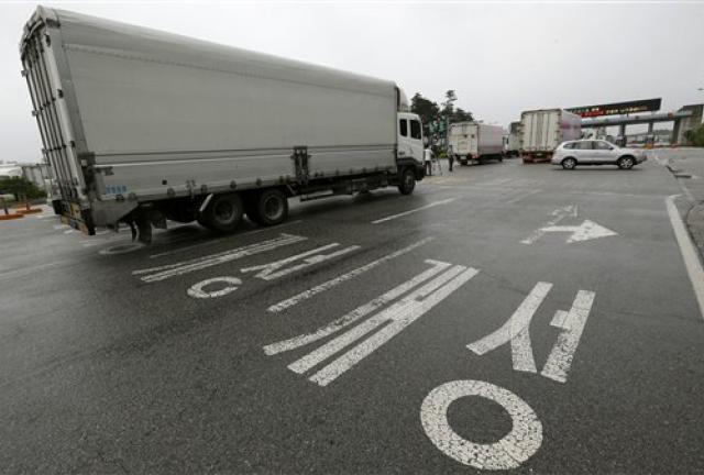 South Korean vehicles leave for South and North Korea's joint Kaesong Industrial Complex to bring back their finished goods and materials at the customs, immigration and quarantine office of the Inter-Korean Transit Office near the border village of Panmunjom, which has separated the two Koreas since the Korean War, in Paju, north of Seoul, South Korea, Monday, July 15, 2013. 