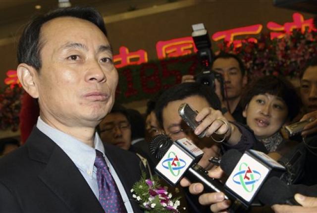 In this Monday, Nov. 5, 2007 photo, Jiang Jiemin, chairman of PetroChina, left, is mobbed by journalists after attending an IPO ceremony for PetroChina at the Shanghai Stock Exchange in Shanghai.