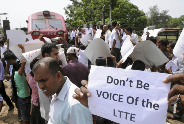 Sri Lankans hold placards while blocking a train carrying Channel 4’s British journalist Callum Macrae, in protest against a documentary made by him, in Anuradhapura, Sri Lanka, Wednesday, Nov. 13, 2013. Sri Lankans hold placards while blocking a train carrying Channel 4’s British journalist Callum Macrae, in protest against a documentary made by him, in Anuradhapura, Sri Lanka, Wednesday, Nov. 13, 2013.