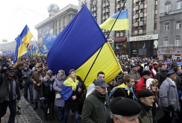 Demonstrators march and carry an Ukrainian flag during a protest in Kiev, Ukraine, Sunday, Nov. 24, 2013. Demonstrators march and carry an Ukrainian flag during a protest in Kiev, Ukraine, Sunday, Nov. 24, 2013.