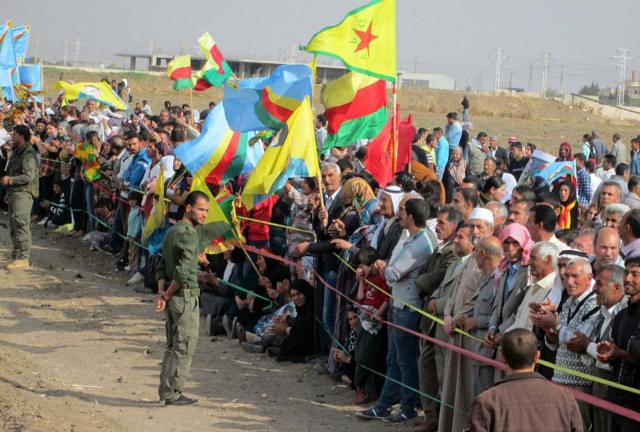 Syrian Kurds wave flags as they gather on the border with Turkey, near Mardin's Nusaybin district, on November 7, 2013. Syrian Kurds wave flags as they gather on the border with Turkey, near Mardin's Nusaybin district, on November 7, 2013.