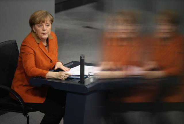  German Chancellor Angela Merkel, reflected through a pane of glass and who is seated due to an injury, gives a government declaration to outline the policy priorities of the new German coalition government of Christian Democrats and Social Democrats on January 29, 2024 in Berlin, Germany.