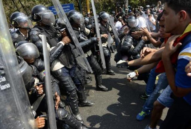 enezuelan students clash with riot police during a protest against the government of President Nicolas Maduro, in Caracas on March 12, 2014. enezuelan students clash with riot police during a protest against the government of President Nicolas Maduro, in Caracas on March 12, 2014.