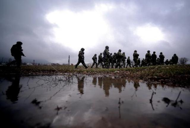 Russian soldiers patrol the area surrounding the Ukrainian military unit in Perevalnoye, outside Simferopol, on March 20, 2014.