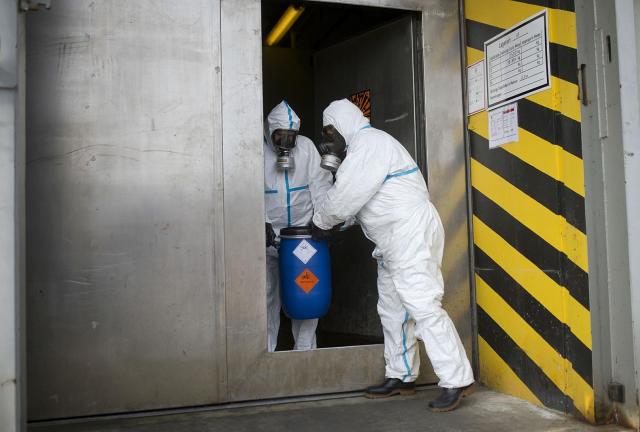 Workers in protective clothing carry a dummy grenade into a bunker during a press day at the GEKA facility on March 5, 2014 in Munster, Germany. Workers in protective clothing carry a dummy grenade into a bunker during a press day at the GEKA facility on March 5, 2014 in Munster, Germany.