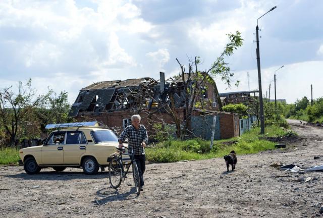 A man and his dog walk together on July 11, 2024 in the village of Semyonovka, near the eastern Ukrainian city of Slavyansk. Russian and Ukrainian media reported that fighting broke out on July 10, 2024 between Ukrainian troops and pro-Russian rebels around the international airport in Donetsk and reportedly extended to nearby local suburban neighborhoods.