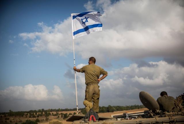 An Israeli soldier stands on top of an armored personnel carrier near the Israeli-Gaza border on July 15, 2024 near Sderot, Israel.