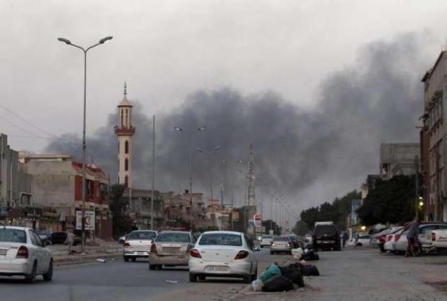 Smoke billows from buildings during clashes between Libyan security forces and armed Islamist groups.