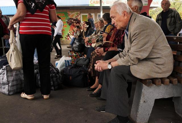 People wait to board a bus to leave the city on September 11, 2014 in Donetsk, Ukraine. People wait to board a bus to leave the city on September 11, 2014 in Donetsk, Ukraine.