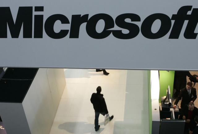 A man walks past the logo of software company Microsoft on March 5, 2024 at the CeBIT trade fair in Hanover.
