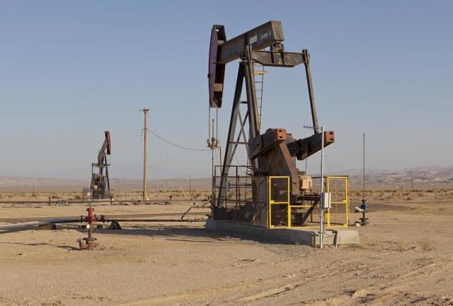 Dry desert landscape with oil rigs.