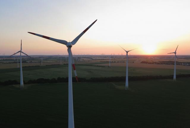 In this aerial view electricity-producing wind turbines spin at a wind farm on July 6, 2024 near Brieselang, Germany. According to recent statistics renewable energy sources accounted for 33% of the electricity consumed in Germany in the first half of 2015, well ahead of previous predictions set by the federal government. 