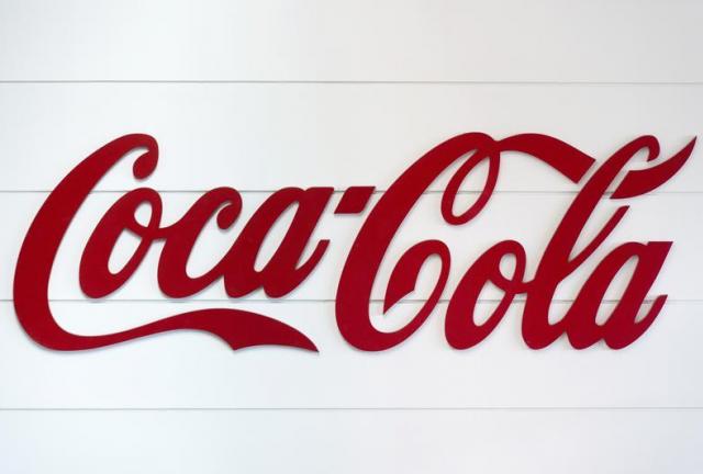 This photo taken on June 7, 2013, in Clamart, near Paris, shows the Coca-Cola logo on the side of an assembly line at a Coca Cola bottling plant. AFP PHOTO / LIONEL BONAVENTURE