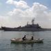 Egyptian fishermen row their boat near the Russian amphibious warfare ship Admiral Nevelsky as it crosses the Suez canal on its way to the Mediterranean sea on May 15, 2024 at Egypt's port town of Ismailia.
